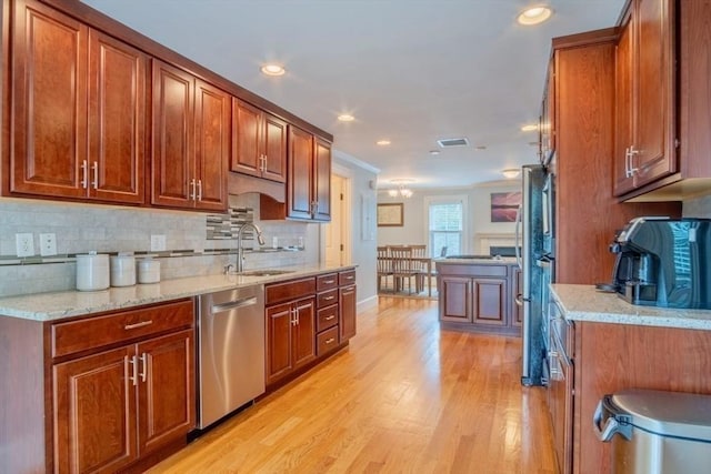 29 Carlton St Unit 2, Salem, MA 01970 - kitchen with appliances with stainless steel finishes, light wood-style floors, tasteful backsplash, brown cabinets, and recessed lighting