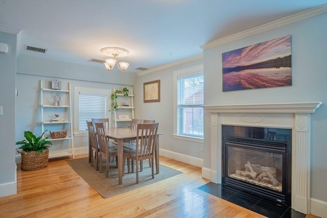 29 Carlton St Unit 2, Salem, MA 01970 - dining space featuring a chandelier, wood finished floors, a fireplace with flush hearth, and ornamental molding