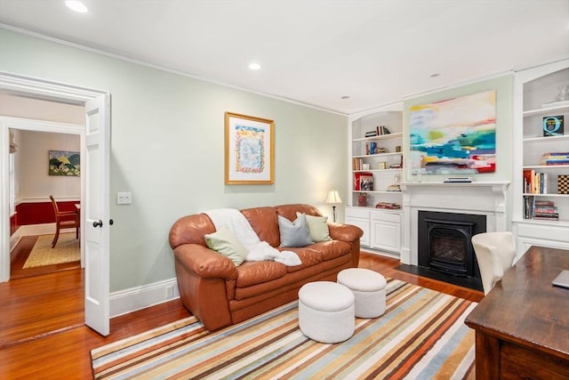 21 Studio Rd, Newton, MA 02466 - living room featuring wood finished floors, a fireplace with flush hearth, baseboards, built in shelves, and ornamental molding