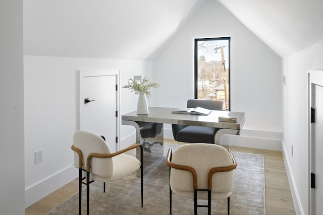 office featuring lofted ceiling, light wood finished floors, and baseboards