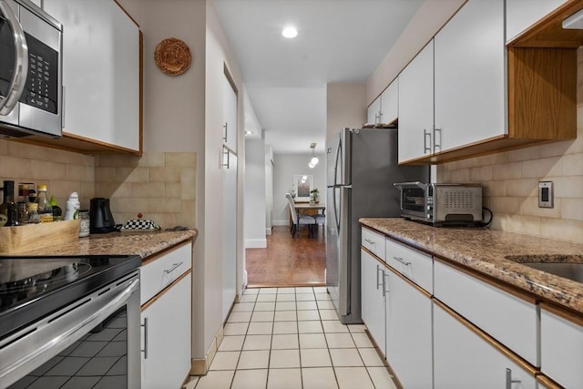 kitchen with backsplash, stainless steel appliances, white cabinets, and recessed lighting