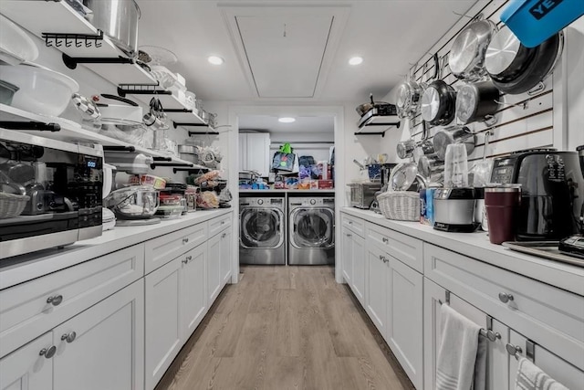 clothes washing area featuring separate washer and dryer and light wood-type flooring