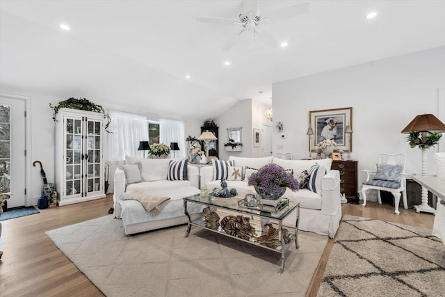 living room featuring ceiling fan, lofted ceiling, and light hardwood / wood-style floors