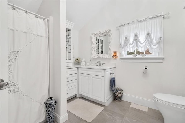 bathroom featuring vanity, lofted ceiling, and toilet