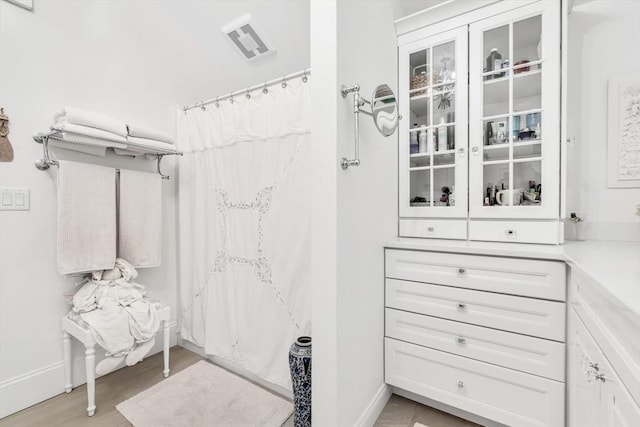 bathroom featuring wood-type flooring and a shower with curtain