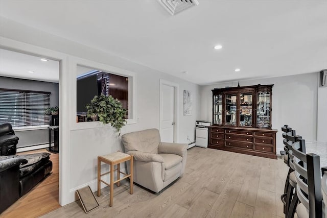 sitting room featuring a baseboard heating unit and light hardwood / wood-style flooring