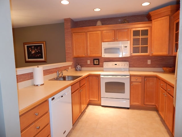 kitchen with kitchen peninsula, sink, light tile patterned flooring, white appliances, and tasteful backsplash