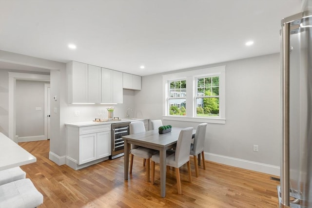6 Ivy Cir, Winchester, MA 01890 - kitchen featuring beverage cooler, light countertops, white cabinets, light wood finished floors, and recessed lighting