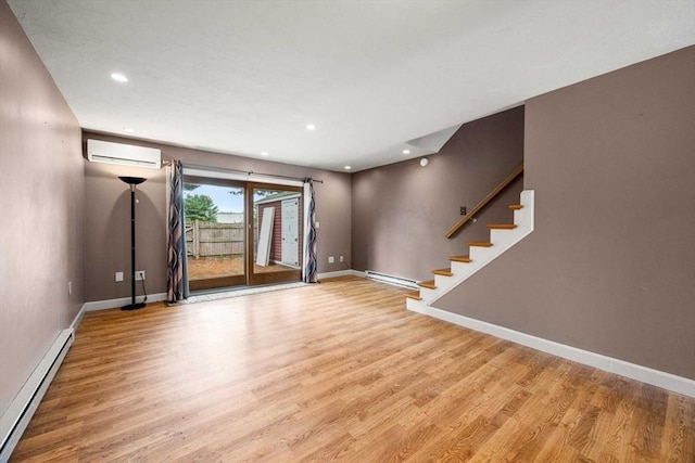 interior space with light hardwood / wood-style flooring, a wall mounted AC, and a baseboard heating unit