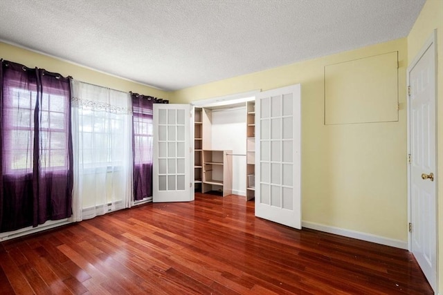 unfurnished room with french doors, a textured ceiling, and hardwood / wood-style flooring