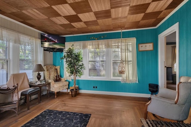 living area featuring crown molding and baseboards