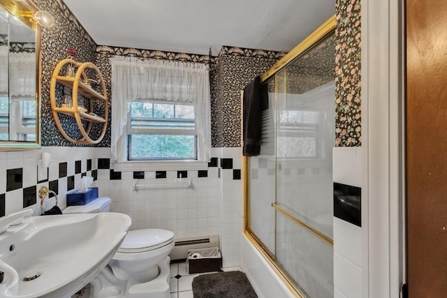 bathroom with a baseboard radiator, toilet, enclosed tub / shower combo, a sink, and tile patterned flooring