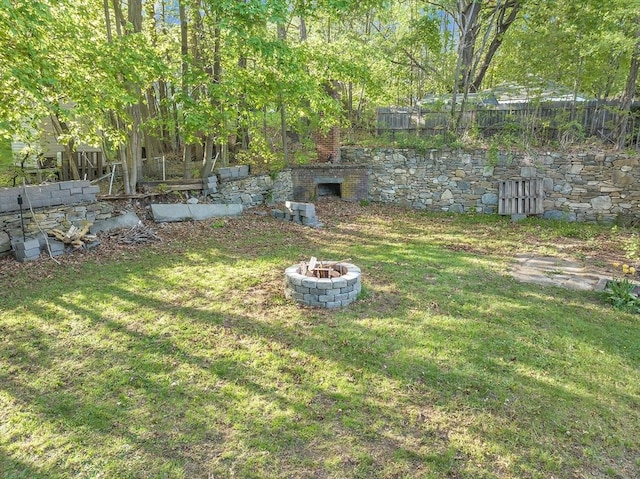 view of yard with an outdoor fire pit and fence