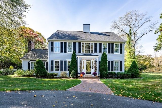 colonial inspired home with a front lawn