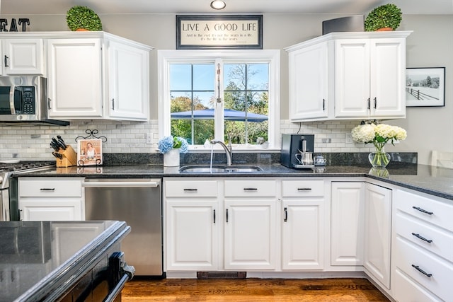 kitchen featuring sink, white cabinets, stainless steel appliances, and backsplash