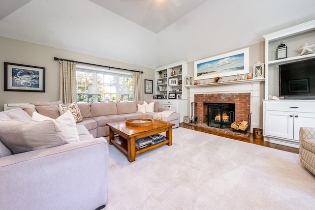 living room with lofted ceiling, a fireplace, and hardwood / wood-style floors