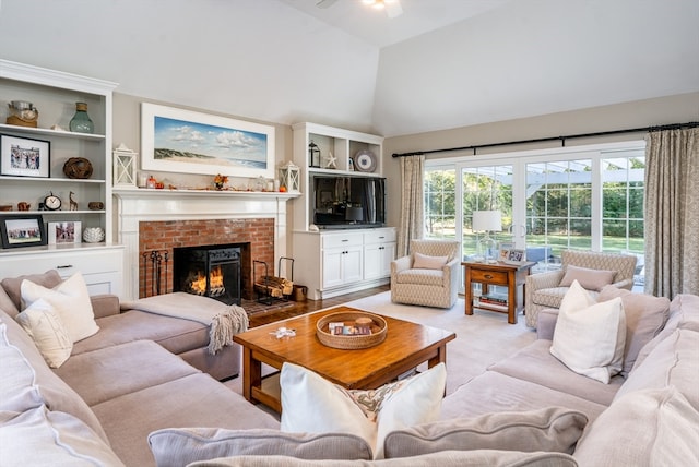 living room with ceiling fan, high vaulted ceiling, and a fireplace