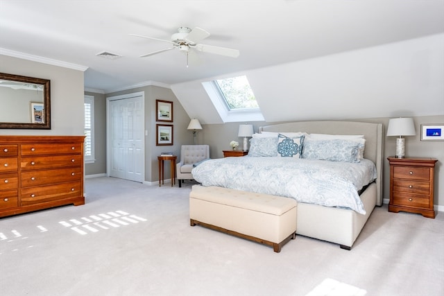 carpeted bedroom with a closet, crown molding, vaulted ceiling, and ceiling fan