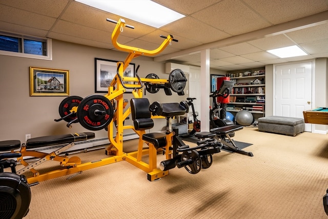 exercise room with a drop ceiling, a wall mounted AC, and carpet flooring