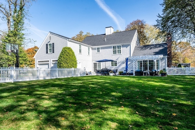 rear view of property featuring a pergola, a lawn, and a garage