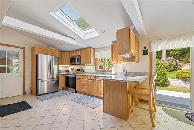 49 Karen Rd, Hanover, MA 02339 - kitchen with appliances with stainless steel finishes, vaulted ceiling, a skylight, a peninsula, and light tile patterned flooring