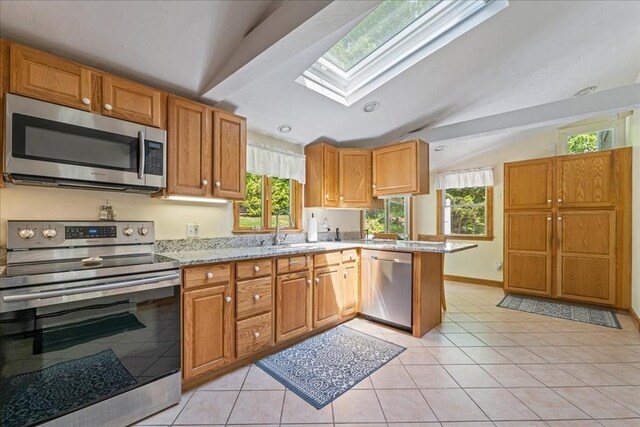 49 Karen Rd, Hanover, MA 02339 - kitchen featuring appliances with stainless steel finishes, a sink, vaulted ceiling, a skylight, and a peninsula
