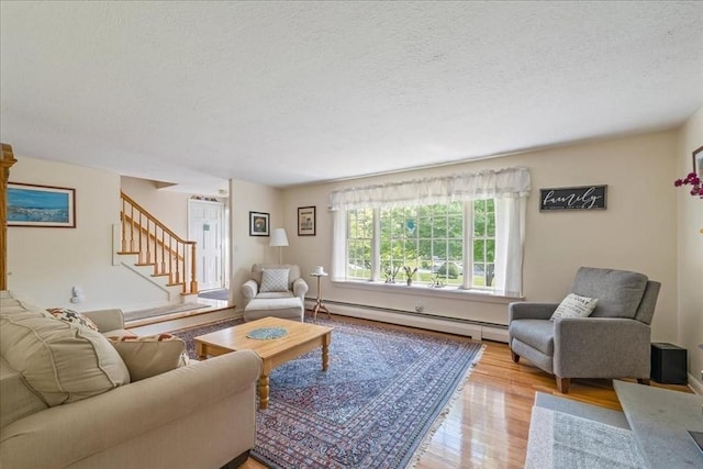 49 Karen Rd, Hanover, MA 02339 - living area featuring a baseboard heating unit, a textured ceiling, light wood finished floors, and stairs