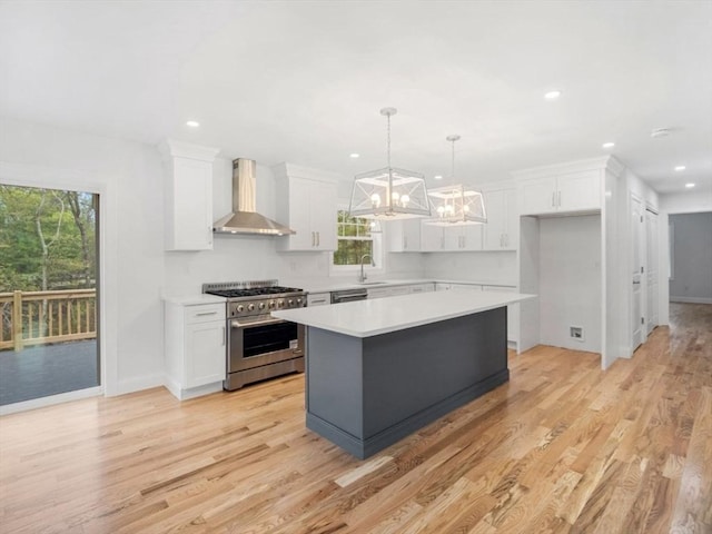 316 Old Westport Rd, Dartmouth, MA 02747 - kitchen with appliances with stainless steel finishes, wall chimney range hood, a chandelier, white cabinets, and a kitchen island