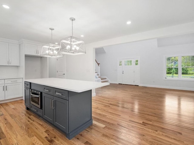 316 Old Westport Rd, Dartmouth, MA 02747 - kitchen featuring oven, white cabinetry, a chandelier, light countertops, and light wood-type flooring