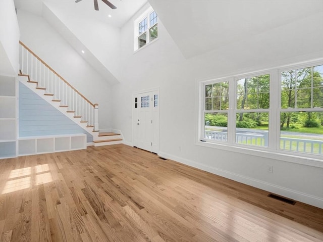 316 Old Westport Rd, Dartmouth, MA 02747 - unfurnished living room featuring wood finished floors, baseboards, ceiling fan, stairway, and a towering ceiling