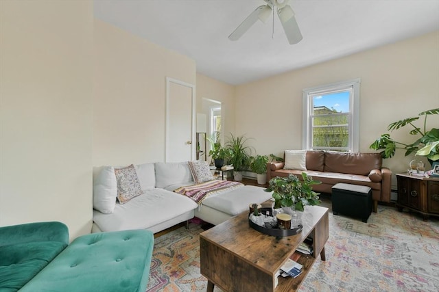 living area featuring ceiling fan and a baseboard heating unit