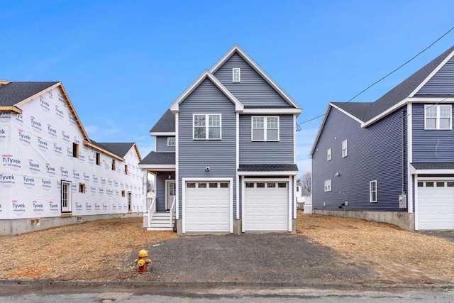 view of front of property featuring a garage, driveway, and roof with shingles