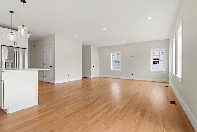 unfurnished living room with visible vents, recessed lighting, light wood-style floors, and baseboards
