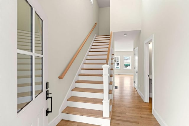 staircase with baseboards and wood finished floors