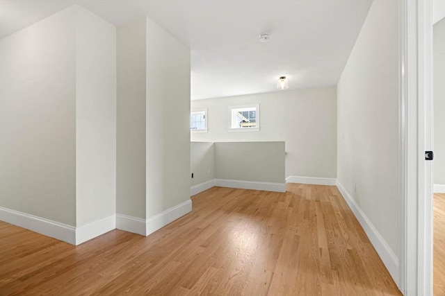 bonus room with baseboards and light wood finished floors