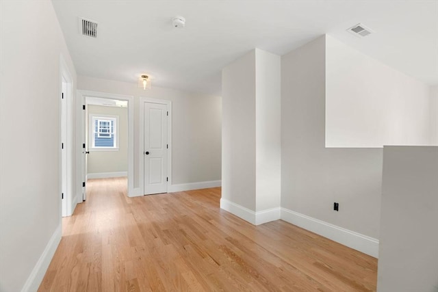 unfurnished room with baseboards, visible vents, and light wood-style floors
