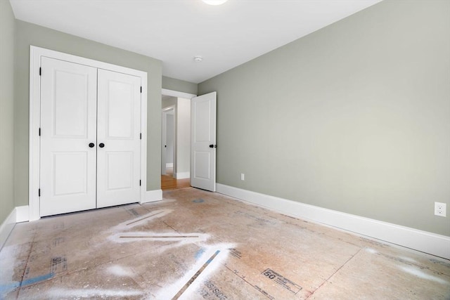 unfurnished bedroom with baseboards and a closet