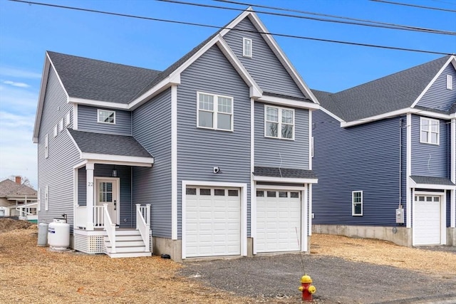 traditional-style house featuring an attached garage, driveway, and roof with shingles