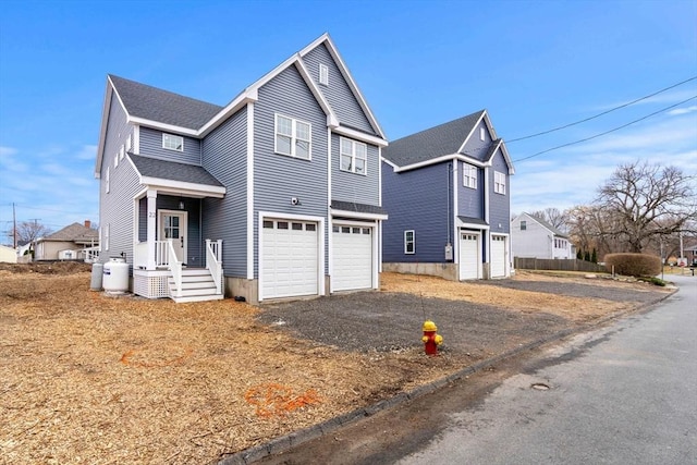 view of front of property with a garage, a shingled roof, and driveway