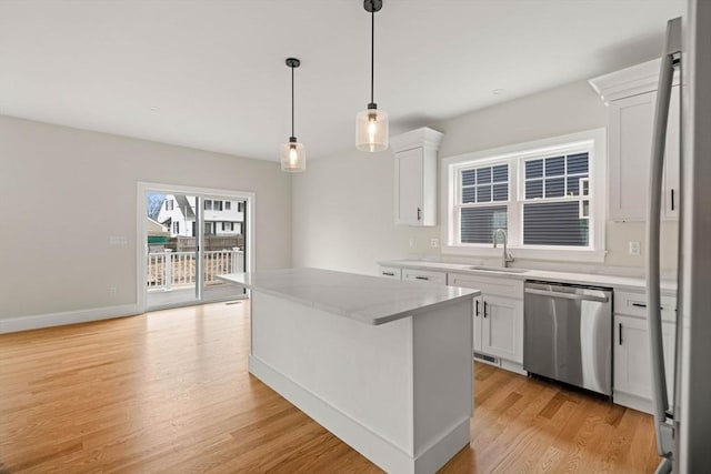 kitchen with a kitchen island, light wood-type flooring, white cabinets, a sink, and dishwasher