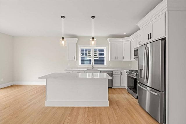 kitchen featuring baseboards, a kitchen island, stainless steel appliances, and white cabinetry