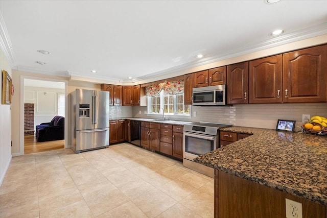 kitchen with crown molding, stainless steel appliances, a sink, and tasteful backsplash