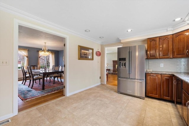 kitchen with decorative backsplash, stainless steel refrigerator with ice dispenser, visible vents, crown molding, and a chandelier