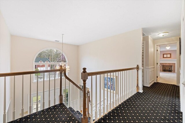 stairway with carpet floors, a notable chandelier, and visible vents