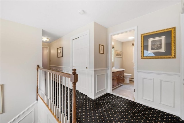 hallway with an upstairs landing and light carpet