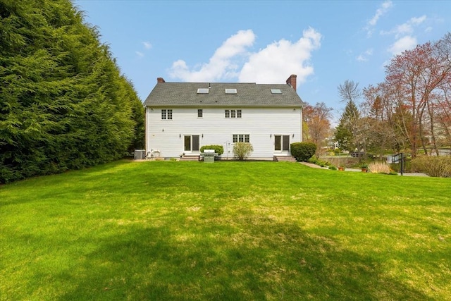 rear view of property with a yard, a chimney, and entry steps