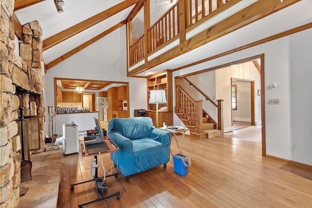 living room with stairs, beam ceiling, high vaulted ceiling, and hardwood / wood-style flooring