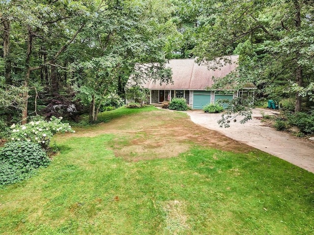 view of front of home with driveway, an attached garage, and a front yard