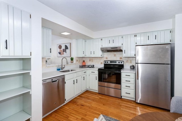 25 Church St Unit 2, Weymouth, MA 02189 - kitchen featuring stainless steel appliances, under cabinet range hood, a sink, light countertops, and decorative backsplash