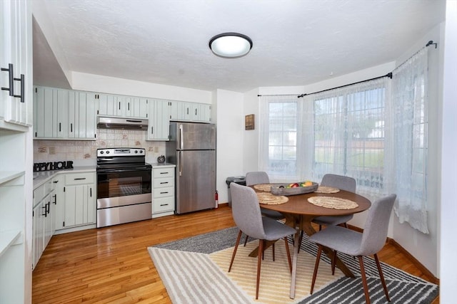 25 Church St Unit 2, Weymouth, MA 02189 - kitchen with appliances with stainless steel finishes, under cabinet range hood, light countertops, backsplash, and light wood-type flooring